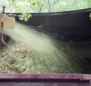 Grinder producing mulch onto a truck.